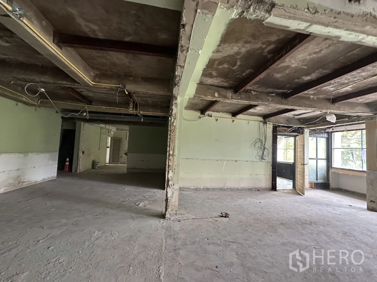 办公空间 出租在Bang Rak, Bangkok - 入口区展示外露天花与布线，木门开启引入自然光。