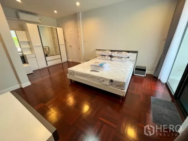 独立式住宅 出租在Phaya Thai, Bangkok - 采光充足的卧室，拼花木地板、双人床与衣柜。