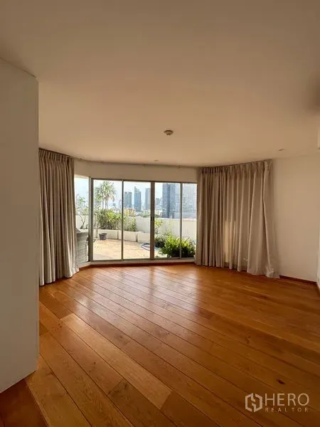 คอนโด ให้เช่าในKhlong Toei, Bangkok - ห้องนั่งเล่นสว่างพร้อมประตูกระจกบานเลื่อนเปิดสู่ระเบียงใหญ่และวิวสกายไลน์