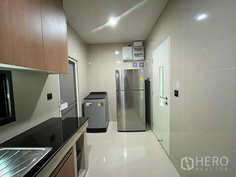 Detached House for rent in Bang Kapi, Bangkok - Sleek kitchen with stainless fridge, washing machine and tiled walls