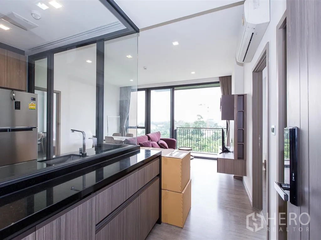 คอนโด for rent in Watthana, Bangkok - ครัวกั้นด้วยกระจก มองไปยังพื้นที่นั่งเล่นและระเบียงวิวสีเขียว
