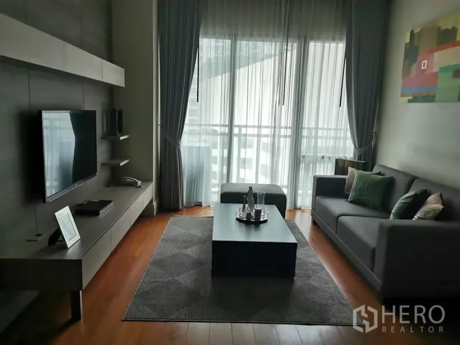 公寓 出租在Khlong Toei, Bangkok - 曼谷空堤区公寓现代客厅，灰色沙发、电视墙、茶几与落地窗阳台