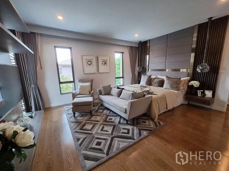 Detached House for rent in Prawet, Bangkok - Spacious master suite featuring sofa seating and a geometric rug.