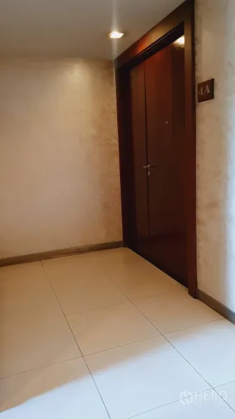 คอนโด ให้เช่าในKhlong Toei, Bangkok - โถงคอนโดพร้อมประตูไม้ทึบและพื้นกระเบื้องใต้ไฟดาวน์ไลท์