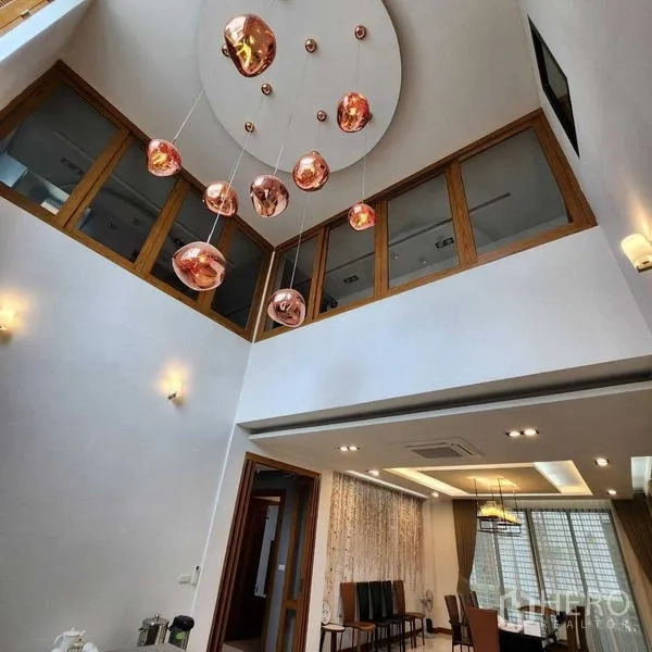 บ้าน ขายในPhra Khanong, Bangkok - โถงกลางบ้านเพดานสูงพร้อมโคมแขวนสีทองแดงและช่องแสงชั้นบน