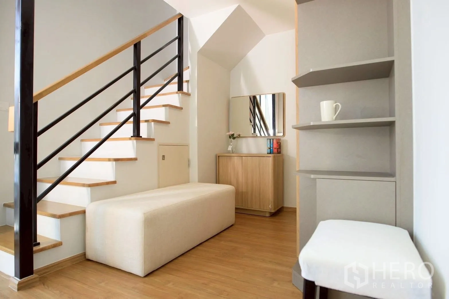 Townhouse for rent or sale in Bang Phli, Samut Prakan - Under-stair area with storage cabinet, long bench and open corner shelves.