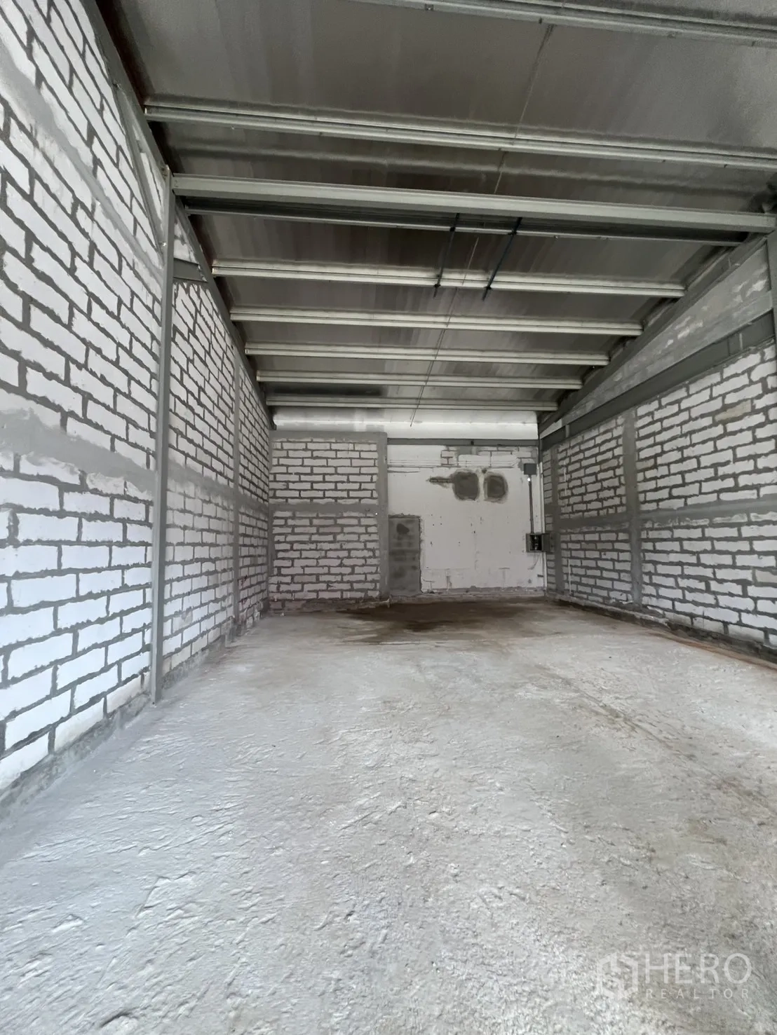 零售空间 出租 - 室内毛坯空间，白色砖墙与金属梁，混凝土地面，进深充足