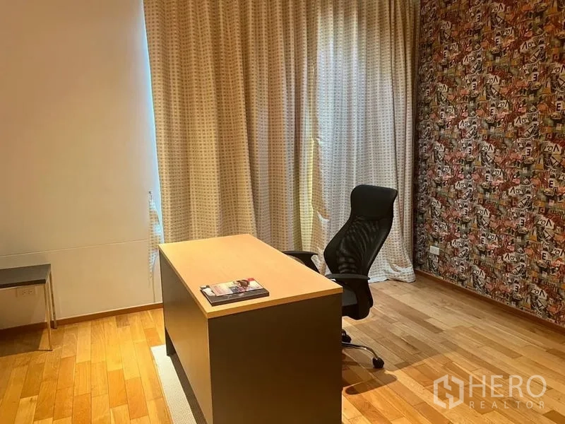 คอนโด ให้เช่าในBangkok - ห้องทำงานเงียบสงบมีโต๊ะไม้ เก้าอี้ตามหลักสรีระ ผนังลายกราฟิก และพื้นไม้