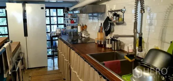 ทาวน์เฮาส์ ให้เช่าในKhlong Toei, Bangkok - ครัวแกลเลย์ท็อปไม้ กระเบื้องซับเวย์สีขาว ชั้นวางของ ตู้เย็นขนาดใหญ่ และก๊อกแบบสปริง