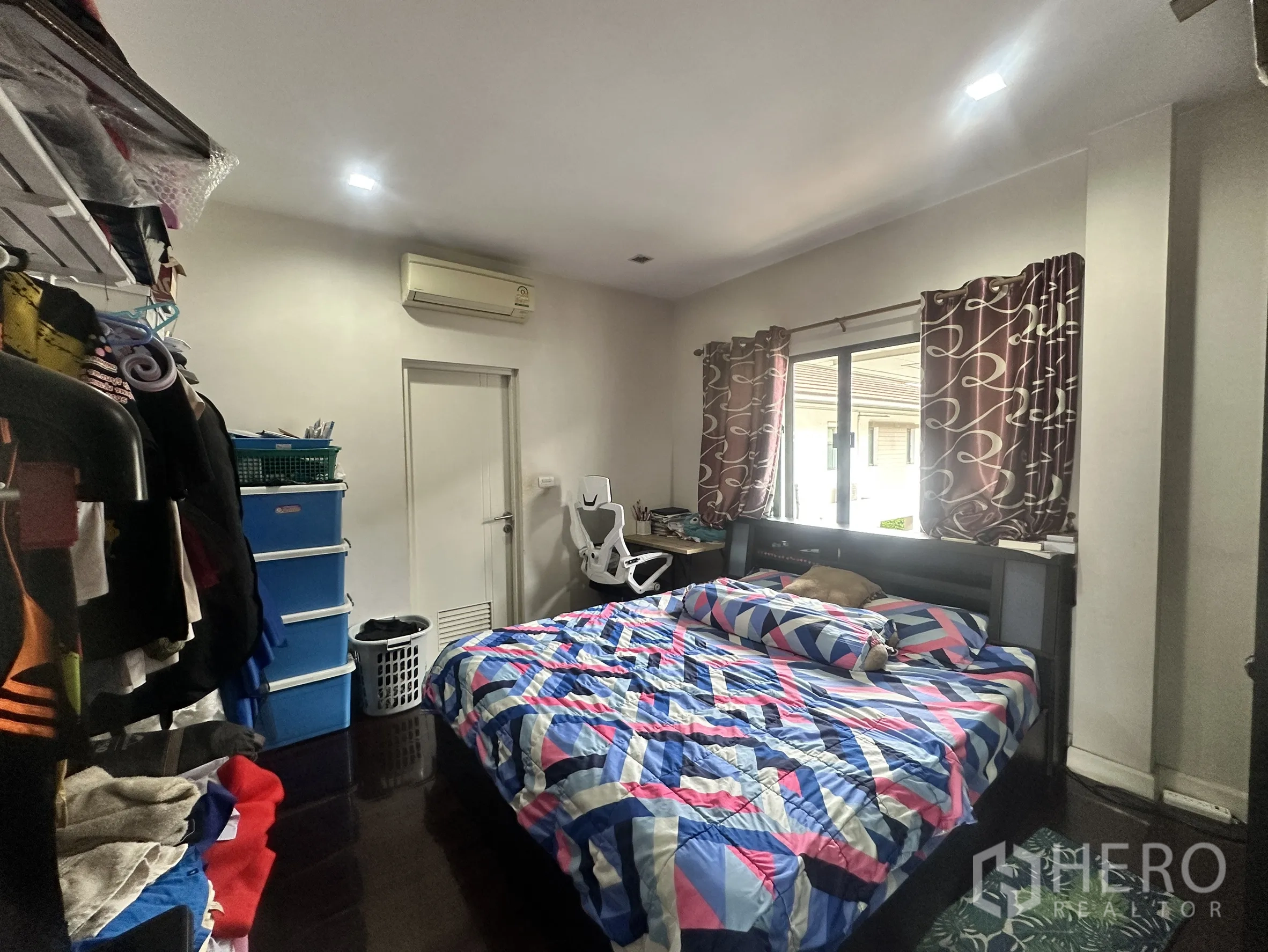 Detached House for sale in Pak Kret, Nonthaburi - Bedroom with double bed, window, air conditioner, and storage shelves.