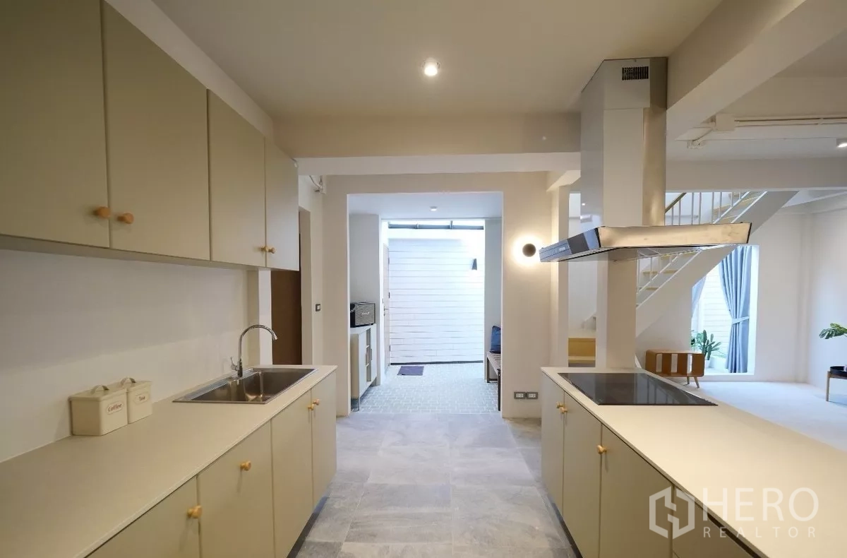 联排别墅 出租或出售在Watthana, Bangkok - 廊式厨房，双排操作台与上柜及不锈钢水槽。