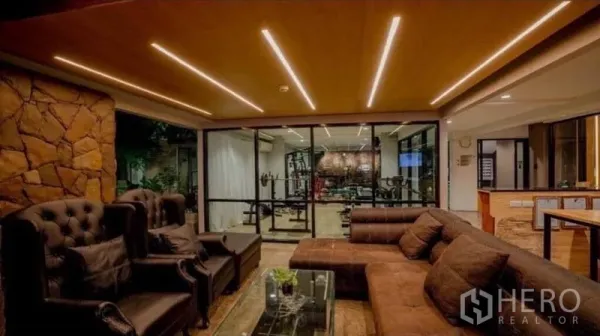 零售空间 出售在Phra Nakhon, Bangkok - 舒适会客区，皮沙发，玻璃墙后为健身房与吧台。