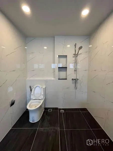 Detached House for rent in Don Mueang, Bangkok - Contemporary shower room with handheld shower and dark tile floor.