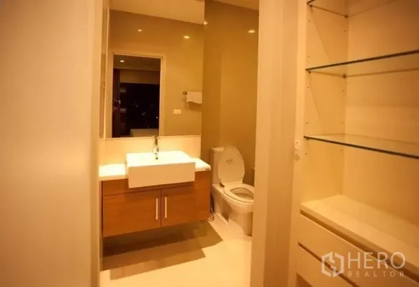 Condominium for rent or sale in Watthana, Bangkok - Modern bathroom with floating vanity, square sink, mirror and glass shelving.