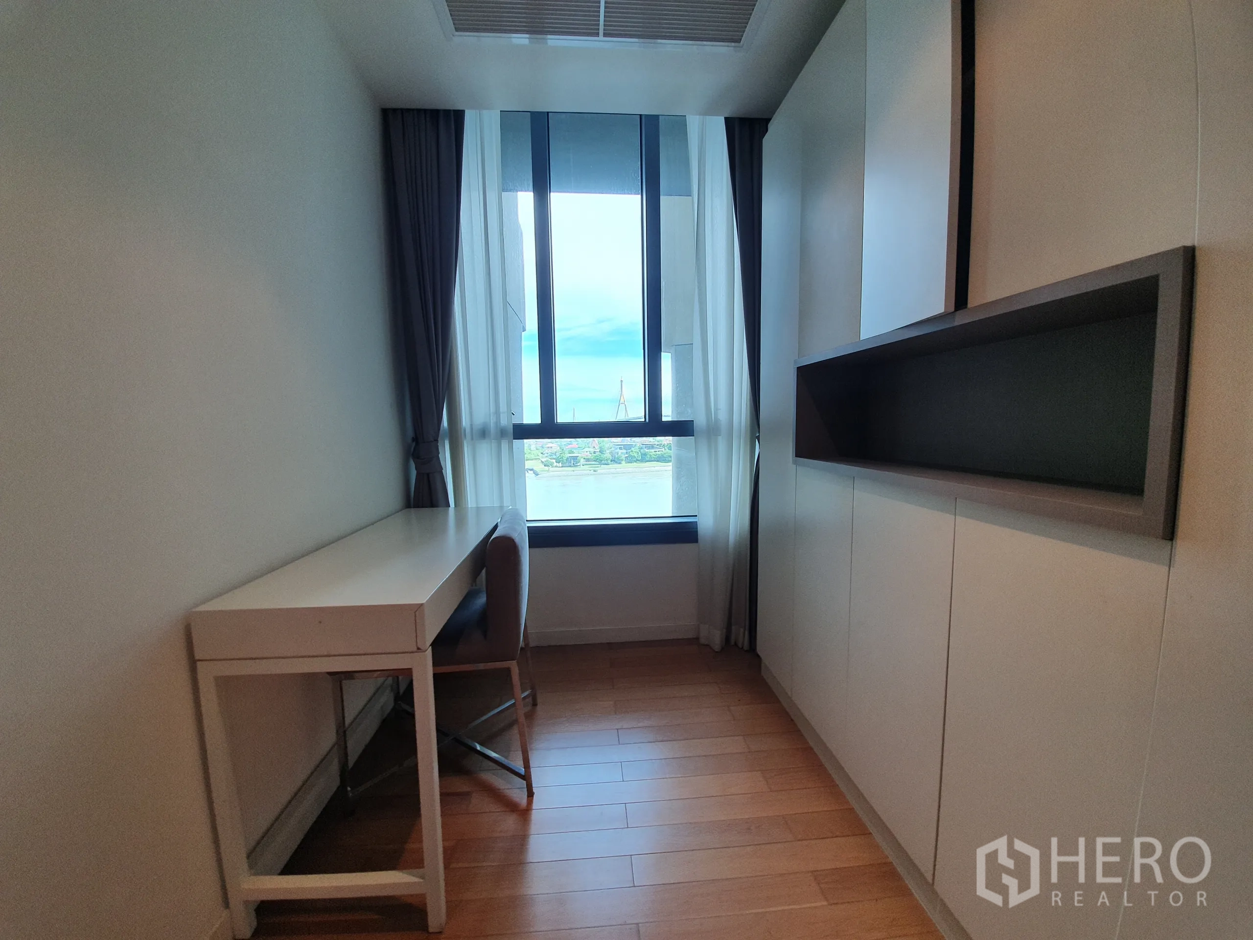 Condominium for rent or sale in Yan Nawa, Bangkok - Compact study room with desk by the window, river view, and built‑in storage.