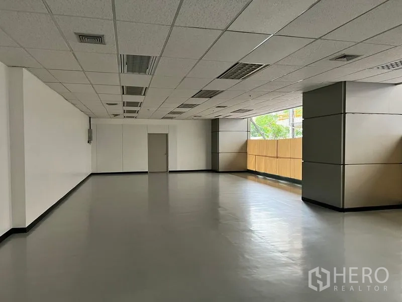 พื้นที่ขายปลีก ให้เช่า - โถงโล่งสำหรับค้าปลีก มีหน้าต่างมุม มุมผนังสีขาว และประตูบริการด้านหลัง พร้อมปรับแต่งได้