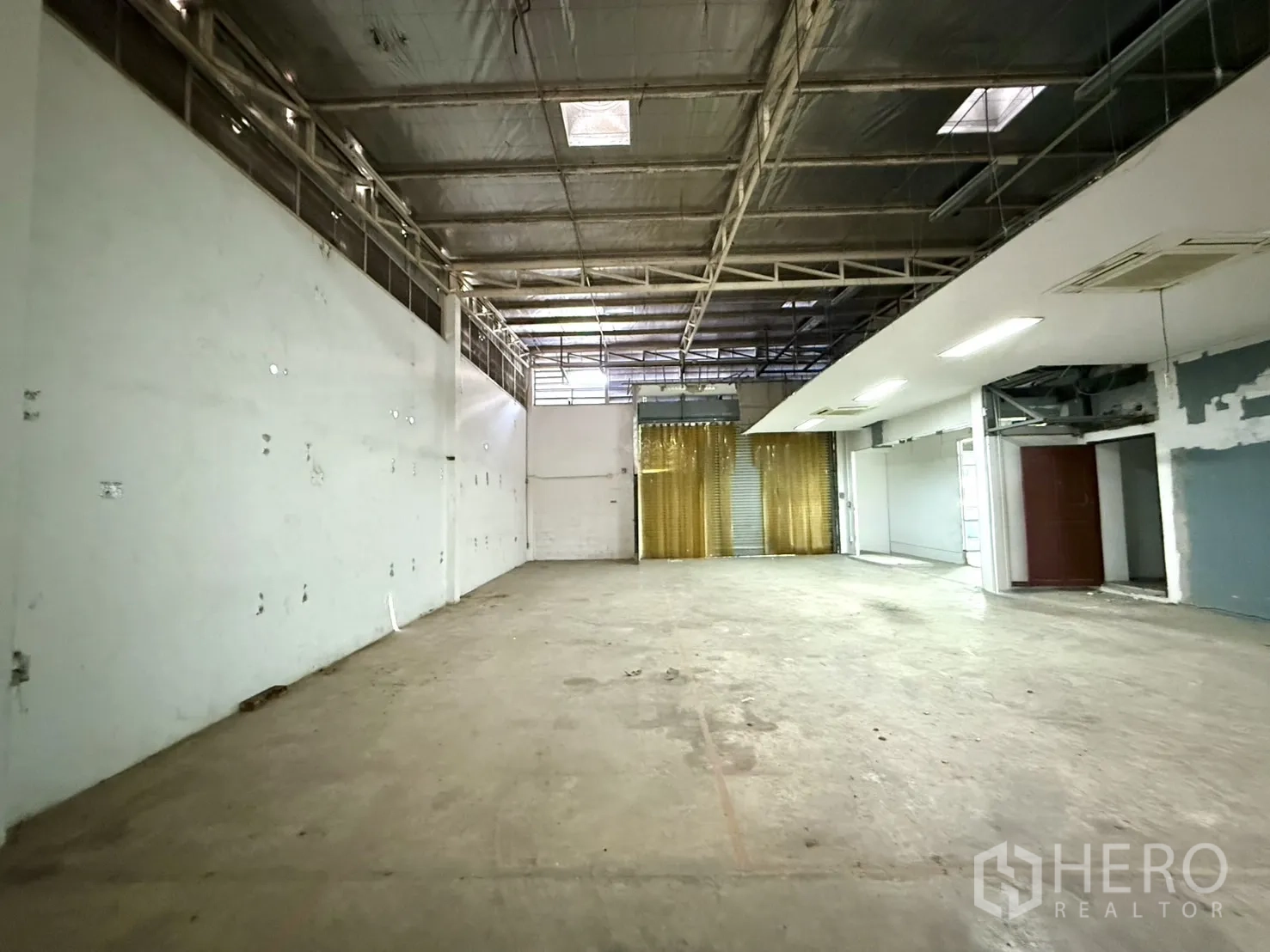Office Space for rent in Bueng Kum, Bangkok - Deep warehouse bay looking toward a roller door with gold curtains.