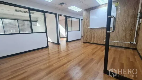 办公空间 出租在Khlong Toei, Bangkok - 主办公区展示多间玻璃隔断、白墙与暖色地板。