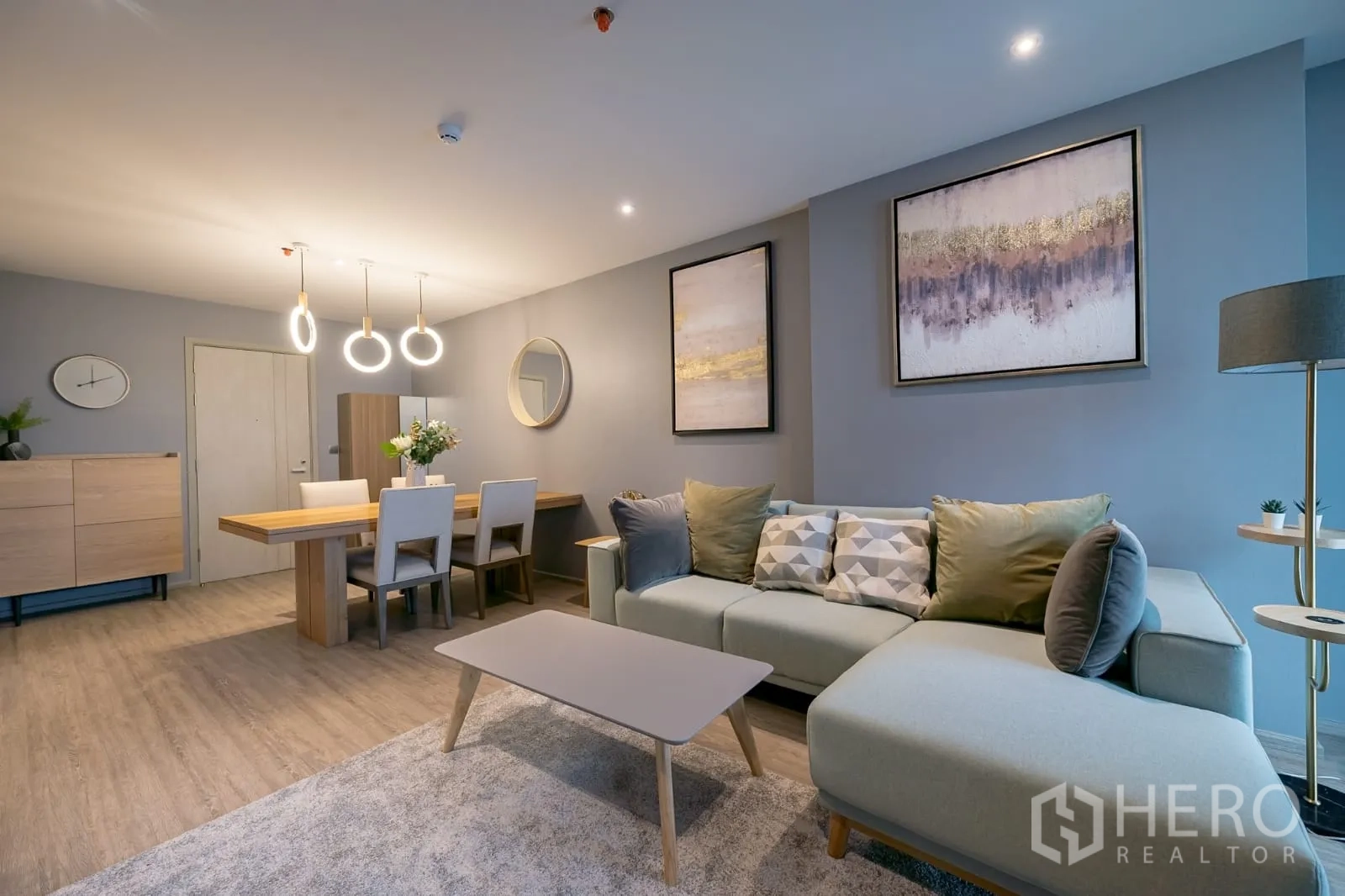 คอนโด ให้เช่าในKhlong Toei, Bangkok - มุมนั่งเล่นอบอุ่น โซฟาโทนพาสเทล ภาพแขวน และโต๊ะอาหาร