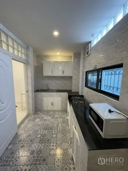 ทาวน์เฮาส์ ให้เช่าในPhra Khanong, Bangkok - ห้องครัวบิลต์อิน พื้นลายกระเบื้อง ตู้สีขาว เตาแก๊สและท็อปสีดำ