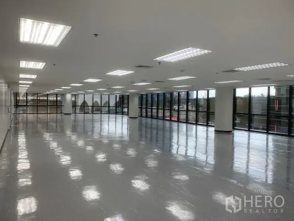 办公空间 出租在Bang Rak, Bangkok - 长条形开放办公区，LED灯阵、中央空调出风口与全景玻璃窗。