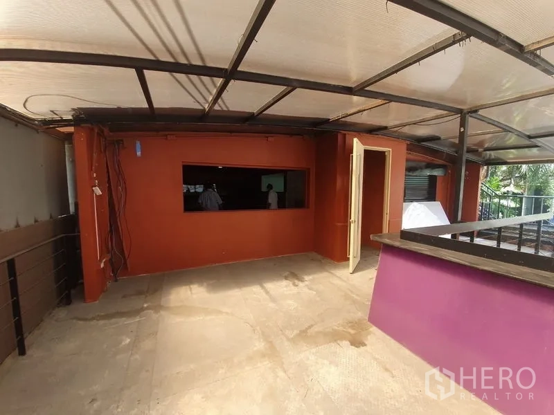 อาคารพาณิชย์ ให้เช่าในKhlong Toei, Bangkok - ระเบียงชั้นบนมุงหลังคาโครงเหล็กพร้อมเคาน์เตอร์บาร์และผนังสีส้ม