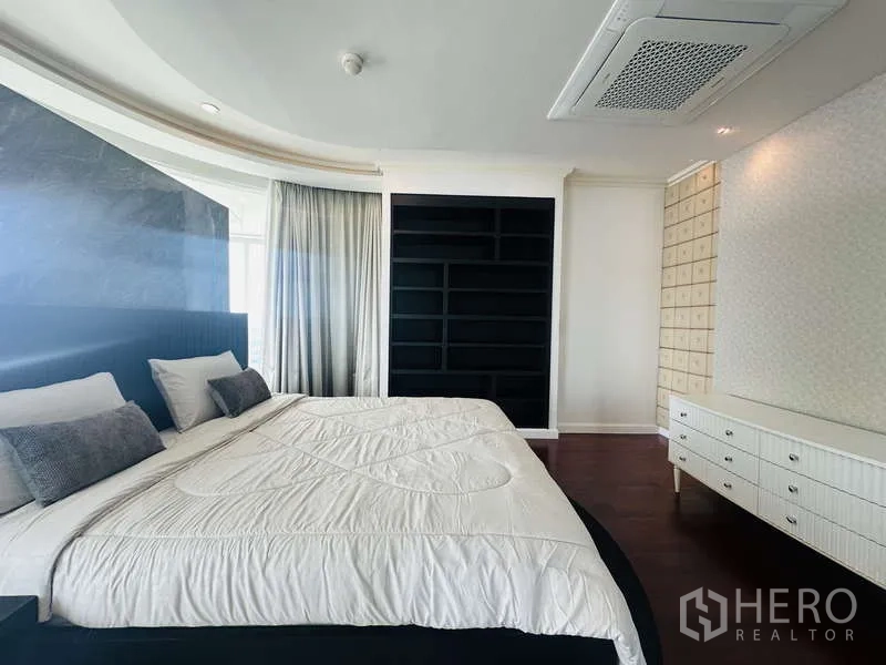 คอนโด ให้เช่าหรือขายในKhlong Toei, Bangkok - พื้นที่พักผ่อนมาสเตอร์พร้อมหัวเตียงบุหนัง ผนังตู้ชั้นวางสีดำ และผ้าม่านยาว