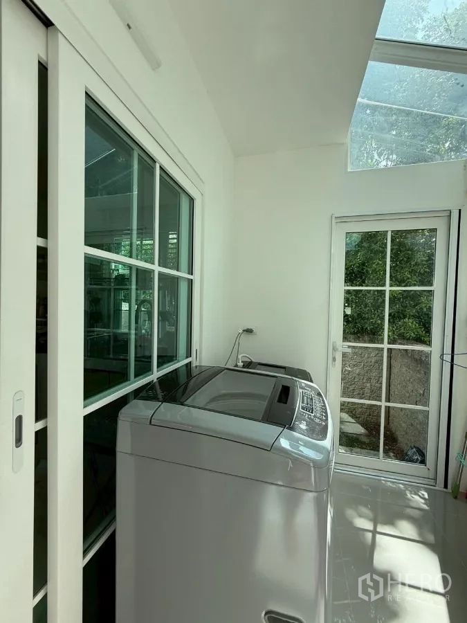 Detached House for rent in Bang Phli, Samut Prakan - Enclosed laundry area with skylight, sliding doors and top-load washing machine.