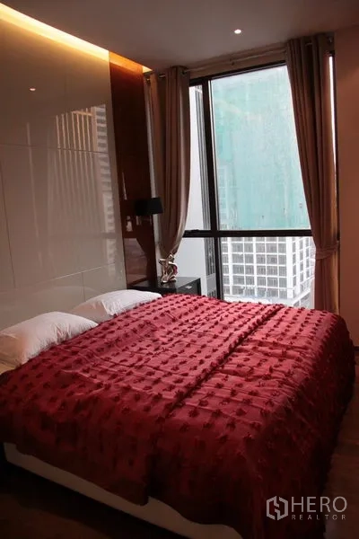 คอนโด ให้เช่าในKhlong Toei, Bangkok - ห้องนอนสว่างด้วยหน้าต่างบานใหญ่ มองเห็นวิวเมือง มีโต๊ะข้างเตียงและผ้าม่าน