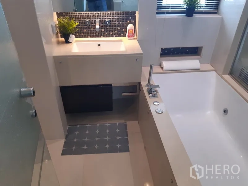 公寓 出租在Khlong Toei, Bangkok - 浴室设深浸浴缸、带马赛克背板的洗手台与窗户。