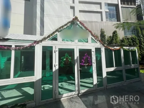 พื้นที่ขายปลีก ให้เช่าในWatthana, Bangkok - อาคารหน้ากระจกกระท่อมสไตล์เรือนกระจก กระจกสีเขียว แต่งพวงมาลัย ในคอร์ตอาคาร