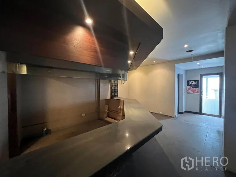 店屋 出售在Bang Rak, Bangkok - 长形吧台，射灯照明，通向阳台的门。