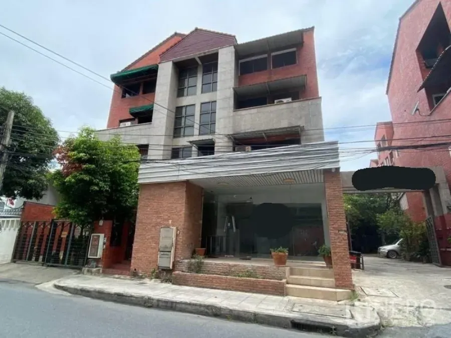 Home Office for rent in Watthana, Bangkok - Brick-and-concrete low-rise building with a glass-fronted entrance.