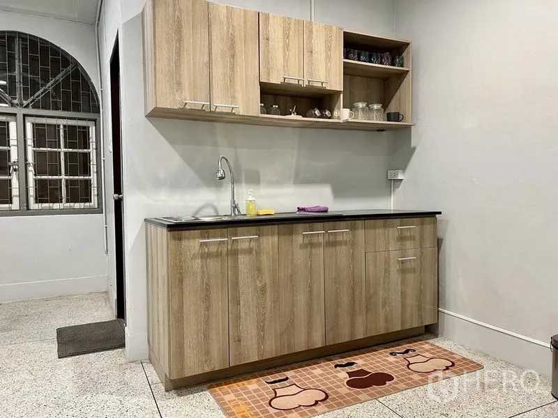 Shophouse for sale in Bang Kho Laem, Bangkok - Compact pantry with wood cabinets, sink and window.