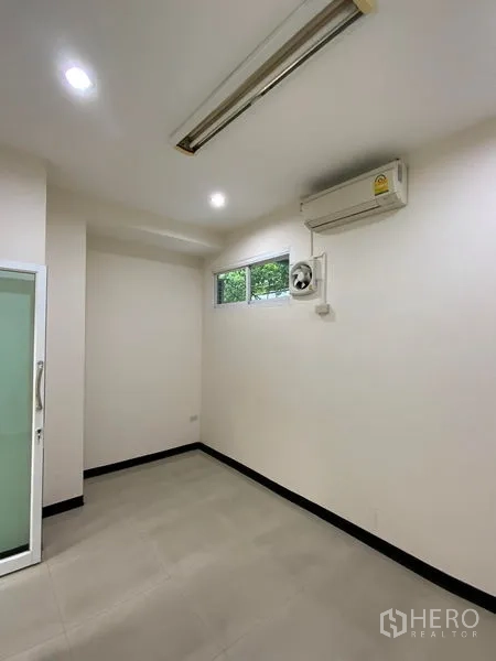 Office Space for rent in Watthana, Bangkok - Private office with small exterior window, ventilation fan, air conditioner, and frosted glass door.