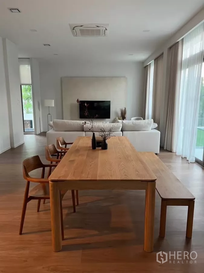 独立式住宅 出租在Saphan Sung, Bangkok - 开放式餐客区，木质餐桌与长凳，墙面悬挂电视。