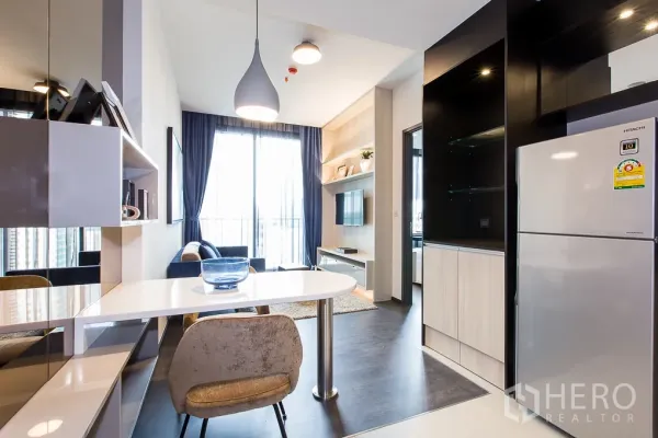 คอนโด ให้เช่าในWatthana, Bangkok - มุมทานอาหารแบบเพนนินซูลาข้างครัว พร้อมโคมไฟแขวนและประตูกระจกออกระเบียง