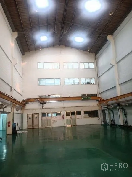 โรงงาน ขายในKhlong Luang, Pathum Thani - พื้นที่ทำงานกว้าง มีช่องแสงบนหลังคา รางเครน และพื้นเขียวมัน.