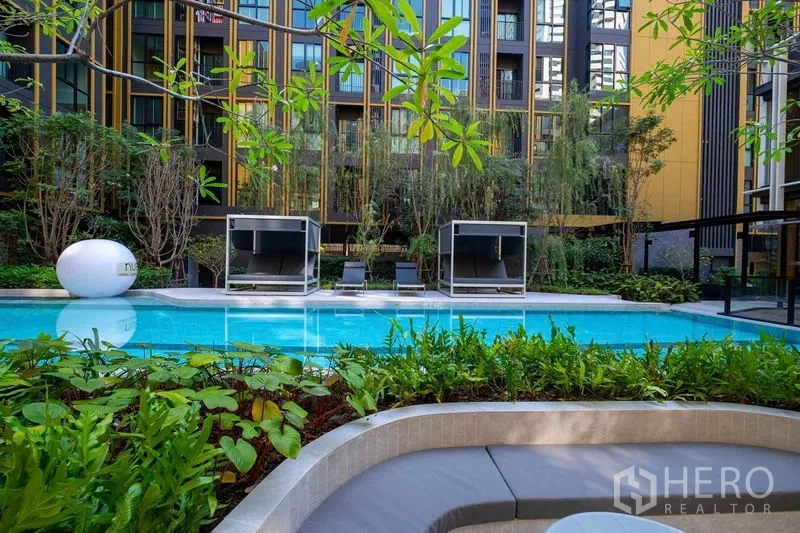 คอนโด ให้เช่าในBang Na, Bangkok - สระว่ายน้ำสไตล์รีสอร์ทพร้อมคาบาน่าและต้นไม้ล้อมรอบภายในโครงการ