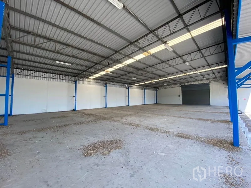 工厂 出租在Nonthaburi - 高挑金属屋顶、采光窗和宽卷闸门的开阔厂房内部