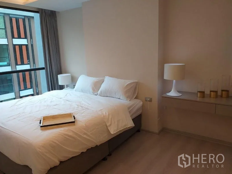 公寓 出租在Khlong Toei, Bangkok - 主卧配大床、床头灯，宽窗引入充足自然光。