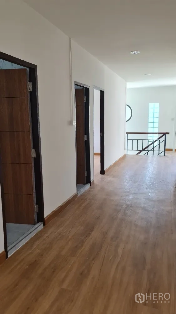บ้านเดี่ยว for rent in Lat Phrao, Bangkok - โถงชั้นบนปูพื้นไม้ มีประตูห้องเรียงตามทางเดิน