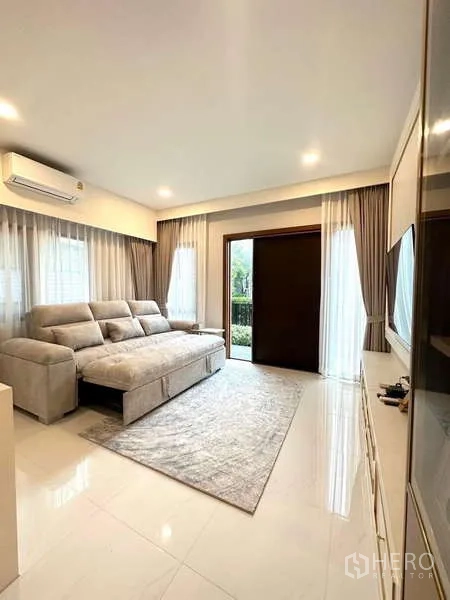 Detached House for rent in Bang Phli, Samut Prakan - Bright lounge with large sectional sofa, sheer curtains and sliding door to the garden.