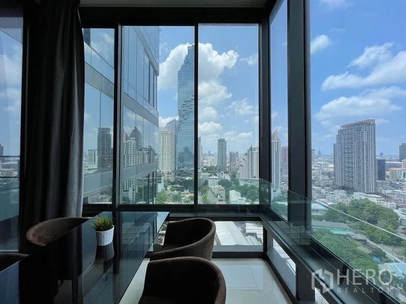 Condominium for rent in Bang Rak, Bangkok - Corner dining area with glass walls and panoramic view of MahaNakhon and the Bangkok skyline near BTS Chong Nonsi.