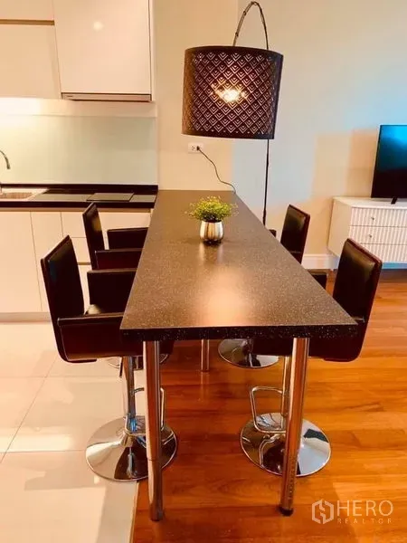 คอนโด ให้เช่าในKhlong Toei, Bangkok - เคาน์เตอร์รับประทานอาหารทรงยาวพร้อมสตูล 4 ตัว ข้างครัวแบบเปิดในคอนโดโมเดิร์น