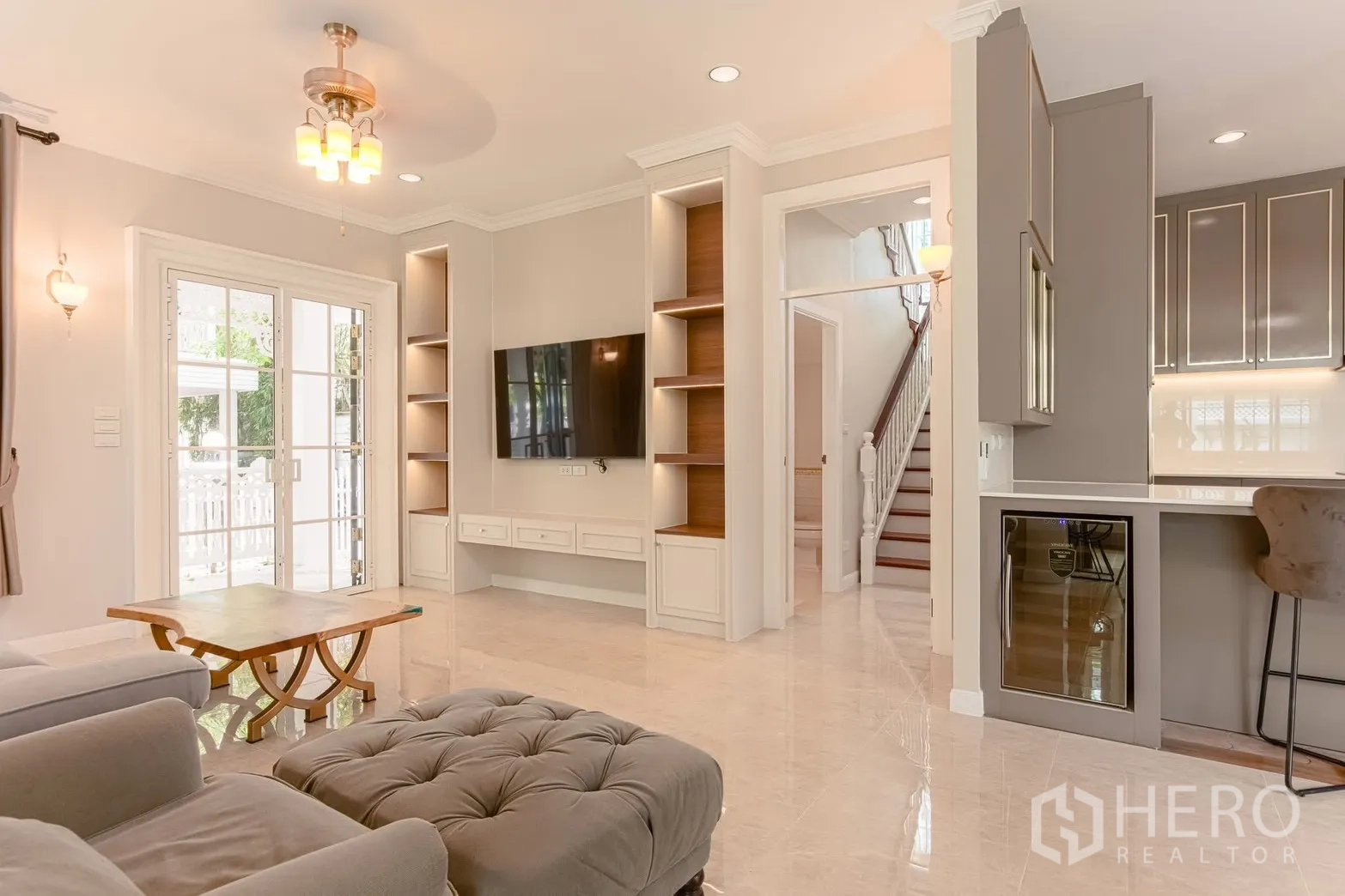 Detached House for rent in Bang Na, Bangkok - Living room media wall with built-in shelves, staircase, and wine chiller.
