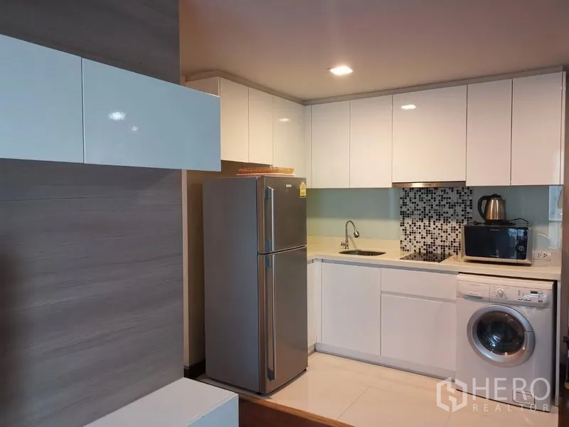 คอนโด ให้เช่าหรือขายในWatthana, Bangkok - มุมครัวอีกด้าน พร้อมผนังกระเบื้องโมเสก เตาไฟฟ้า และตู้เก็บของบิวท์อิน