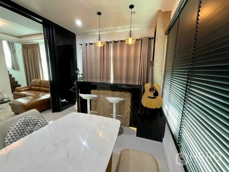 บ้าน ขายในBang Sao Thong, Samut Prakan - มุมรับประทานอาหารพร้อมเคาน์เตอร์บาร์ โคมไฟห้อย โต๊ะหินอ่อน และกีตาร์ข้างหน้าต่าง