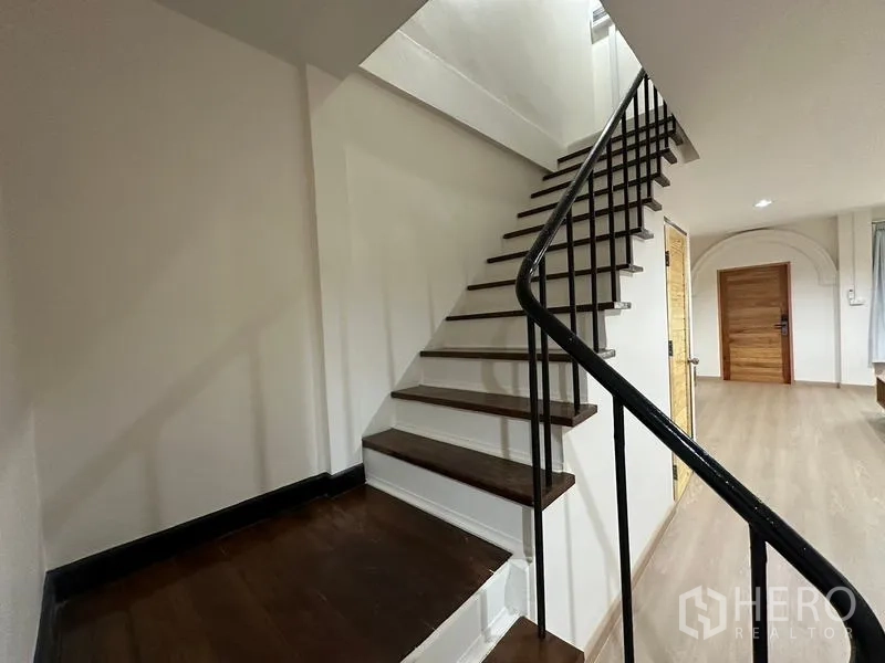 ทาวน์เฮาส์ ให้เช่าหรือขายในPhra Khanong, Bangkok - บันไดไม้พร้อมราวเหล็กสีดำ แบบใกล้ชิด