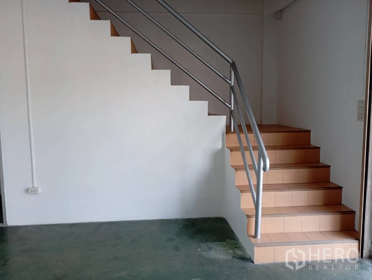 Warehouse for rent in Bang Phli, Samut Prakan - Staircase with metal handrail rising from the warehouse office area.